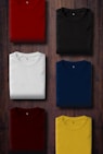 assorted color folded shirts on wooden panel