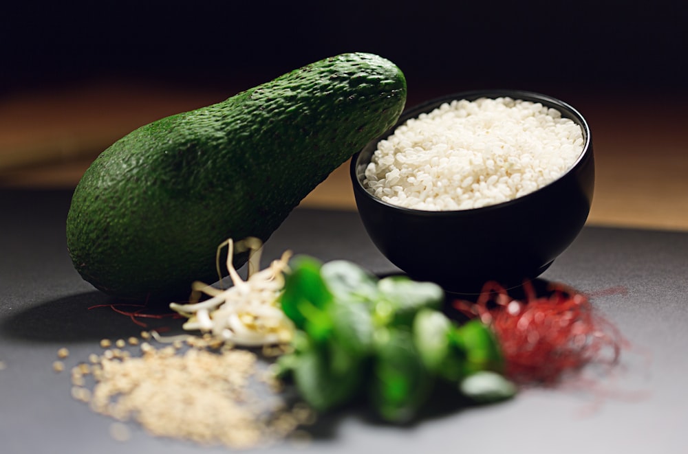 avocado fruit near cooked rice and sliced green bell pepper