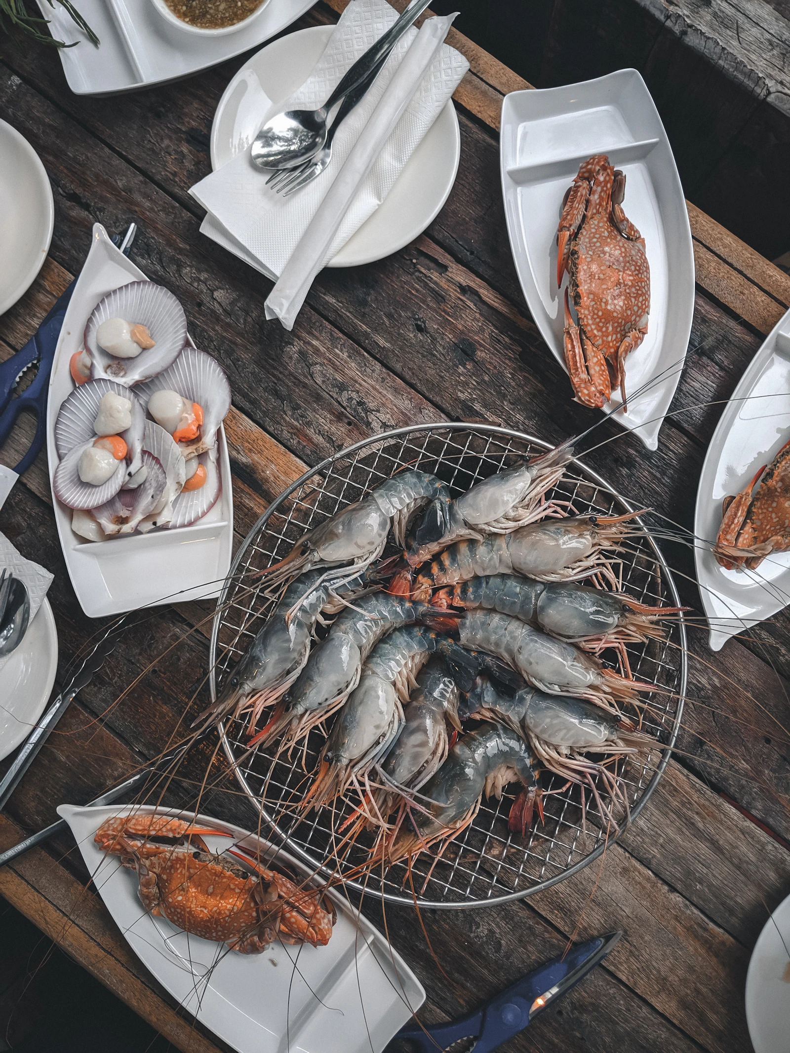Plateau de fruits de mer : crevettes, crabe et coquilles Saint-Jacques sur une table en bois