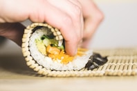 person rolling sushi