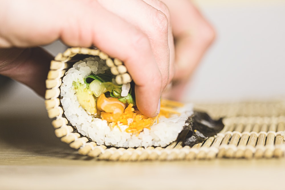 Person, die Sushi rollt