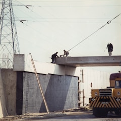 three people working bridge during daytime