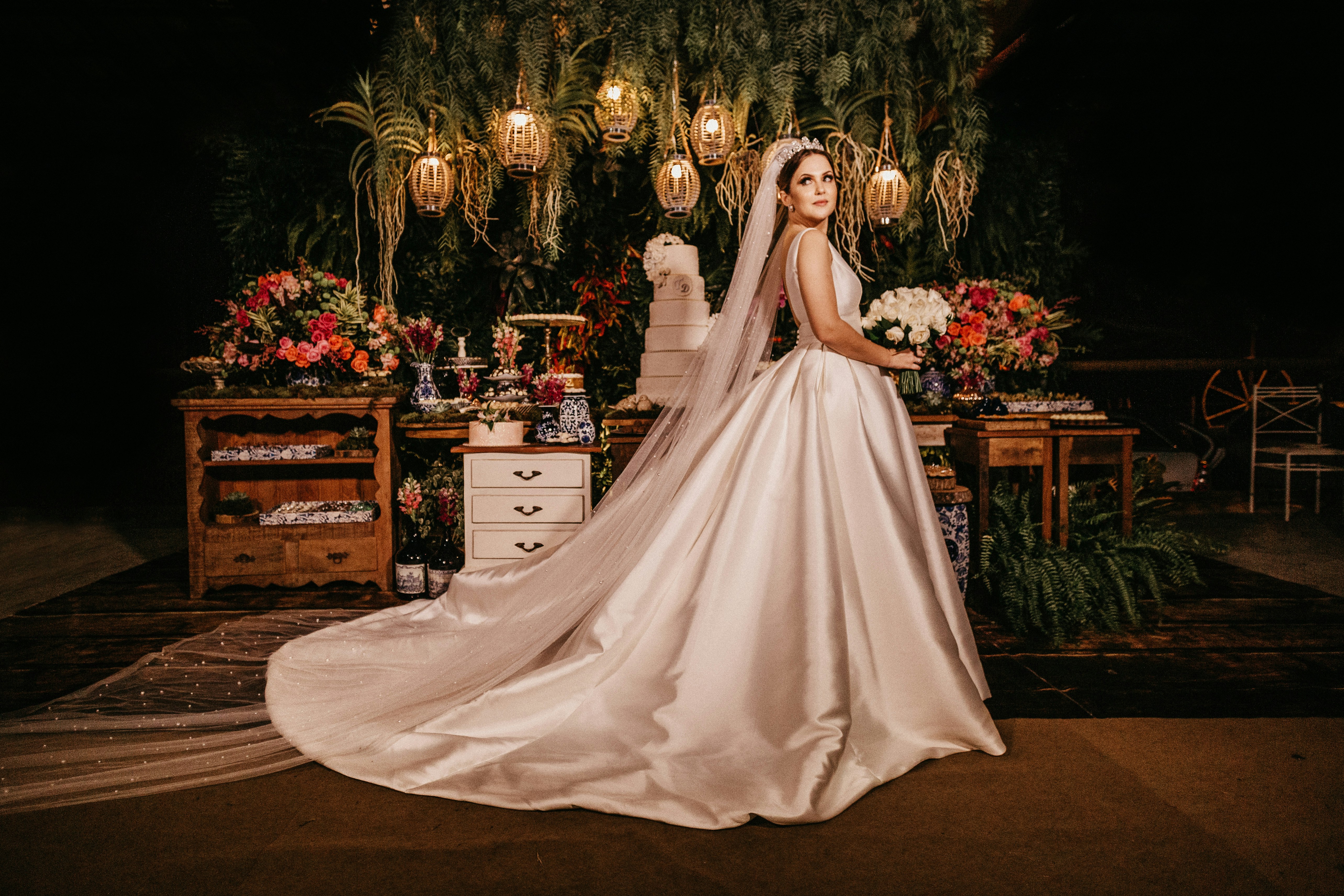 bride holding flower standing near furniture painting