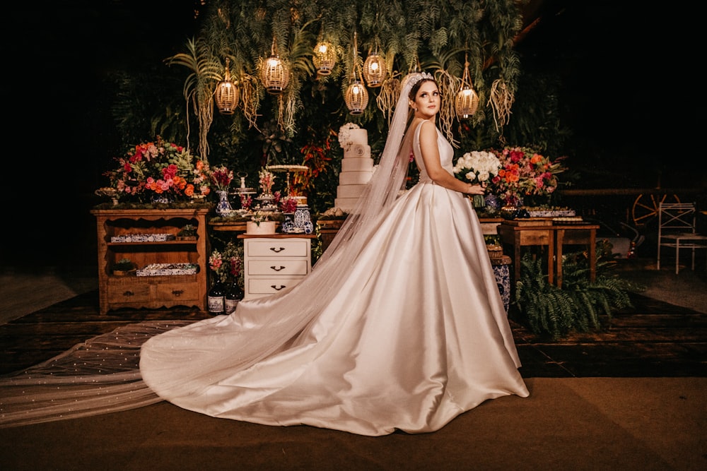 bride holding flower standing near furniture painting