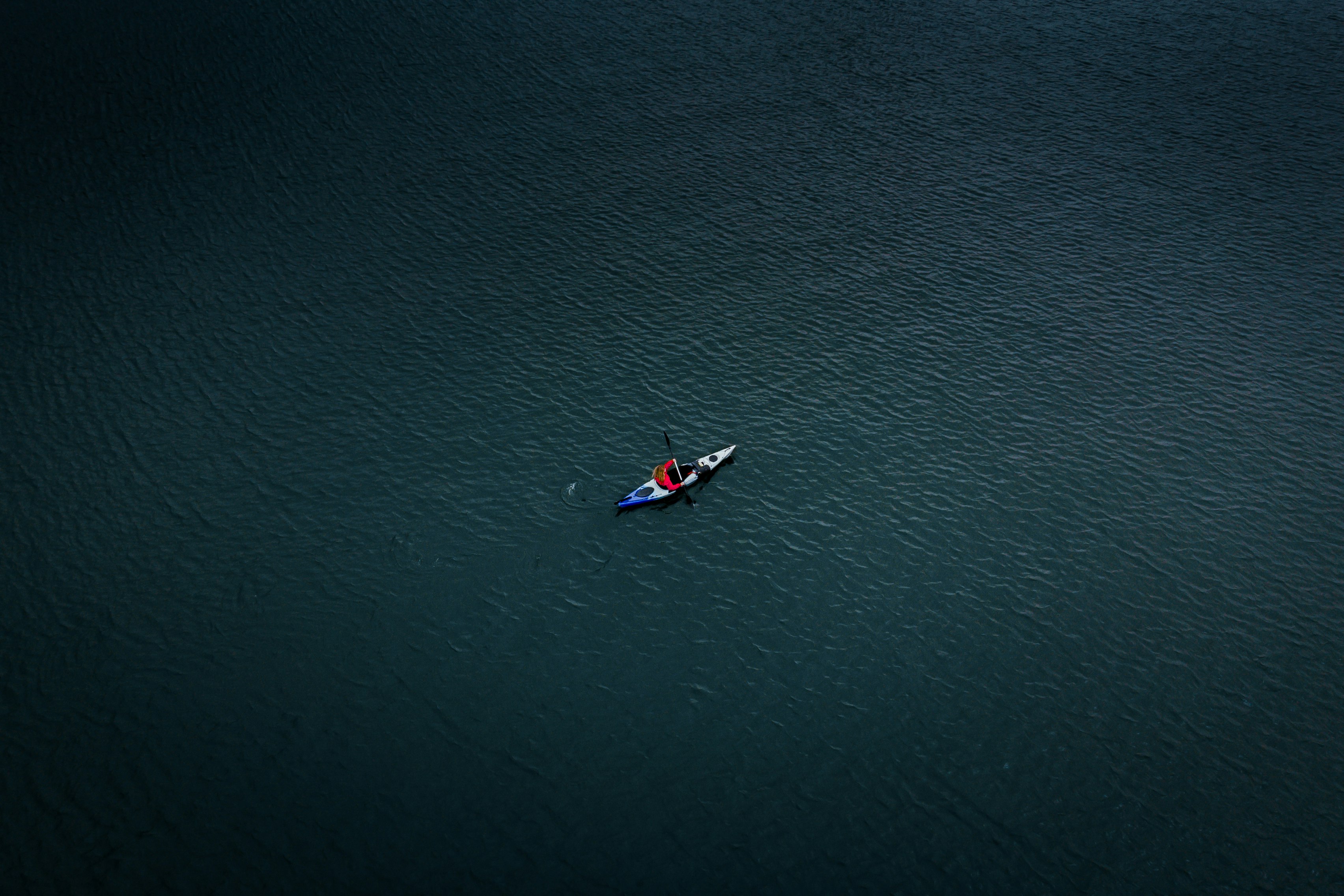 aerial photo of man kayaking on sea