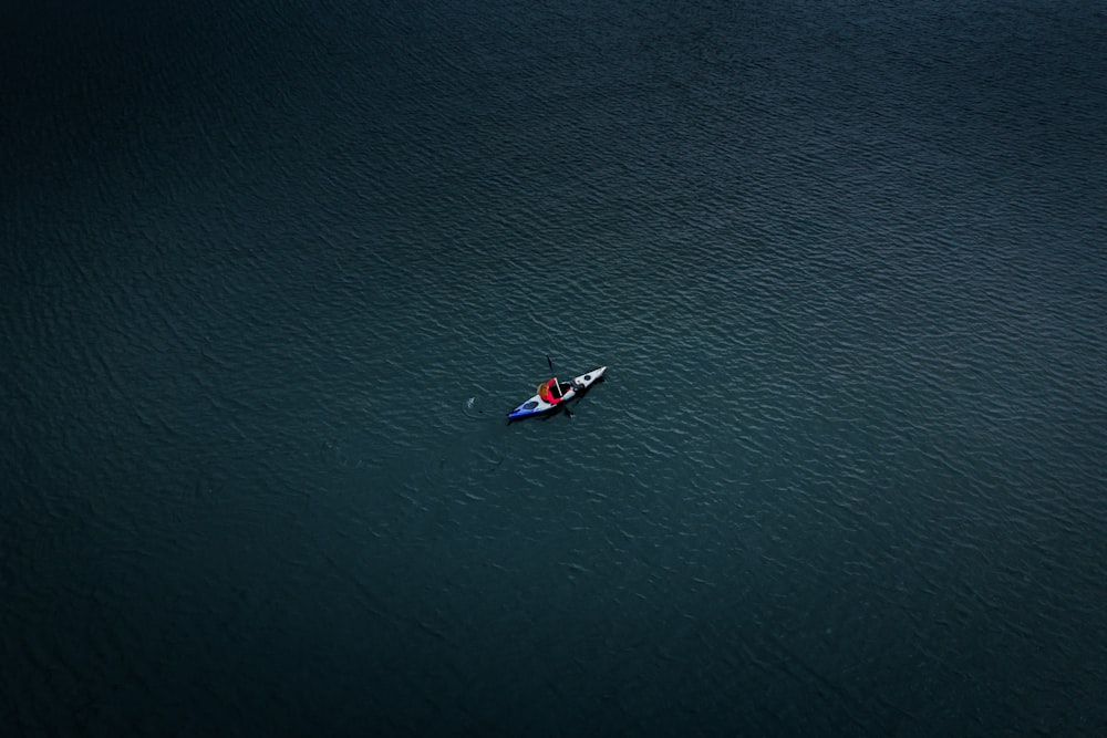 aerial photo of man kayaking on sea