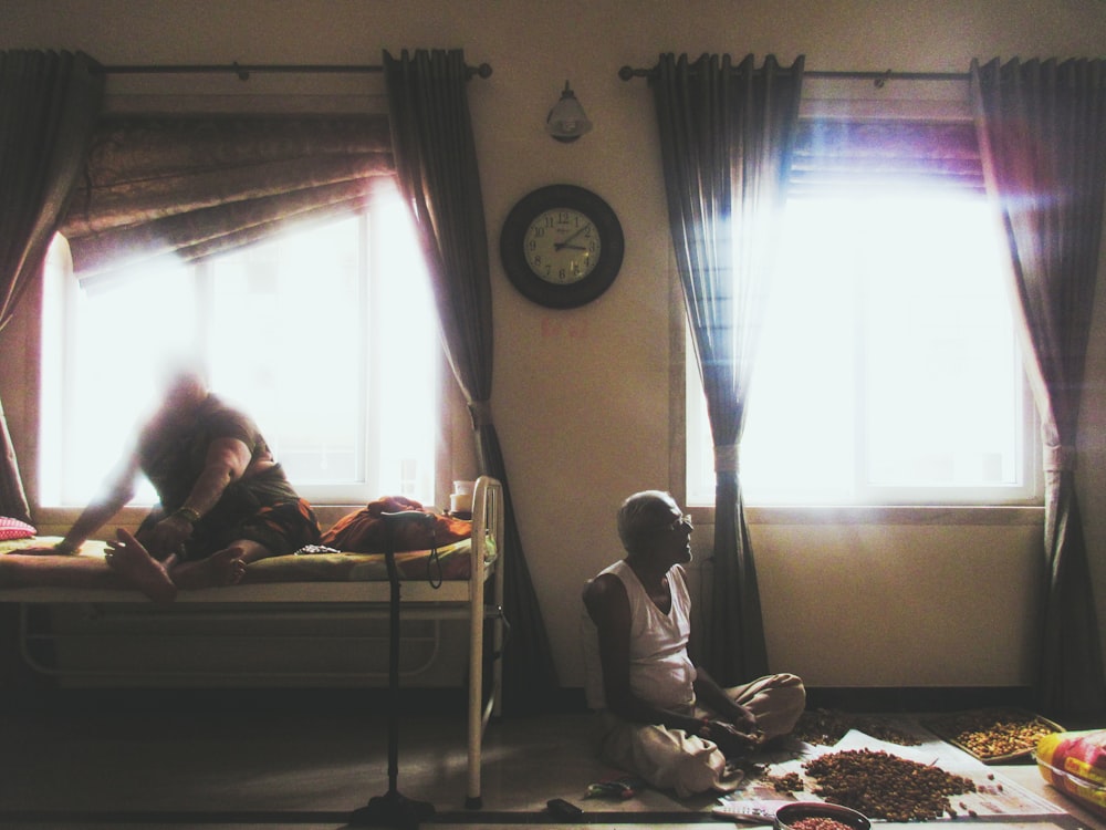 sitting man wearing white shirt inside room