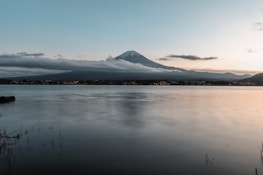 A peaceful view of Mount Fuji reflected in a calm lake during autumn.
