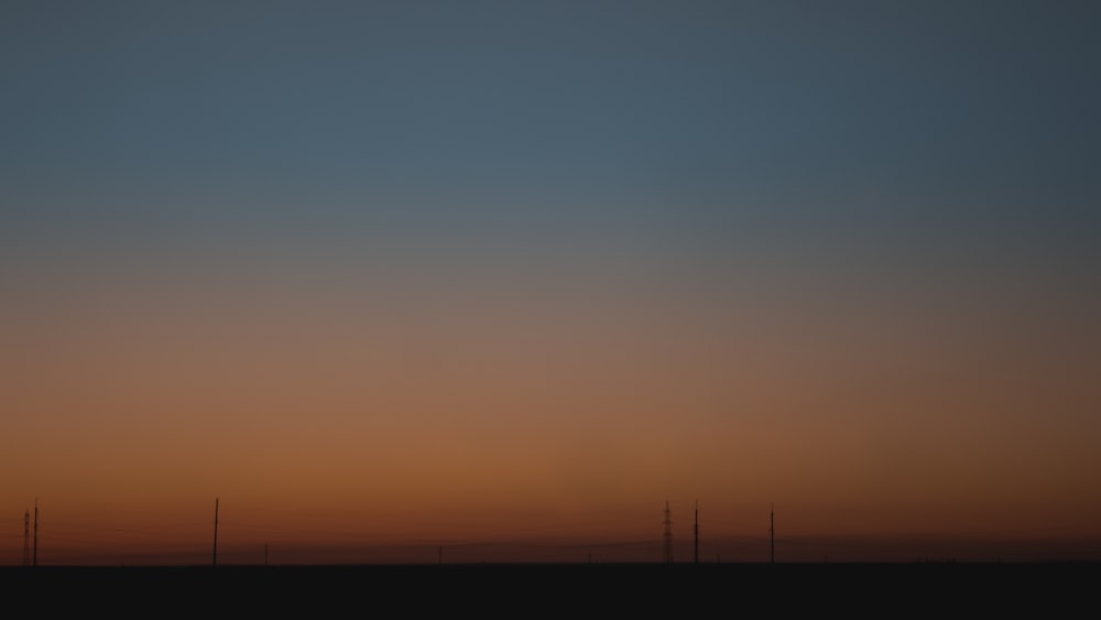 a plane flying in the sky at sunset