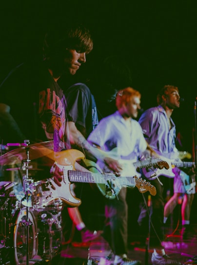 Dynamic shot of the band performing live with anime-style virtual avatars projected behind them.