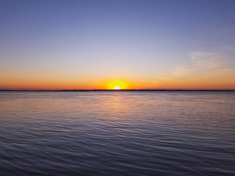 mar calmo azul durante o nascer do sol