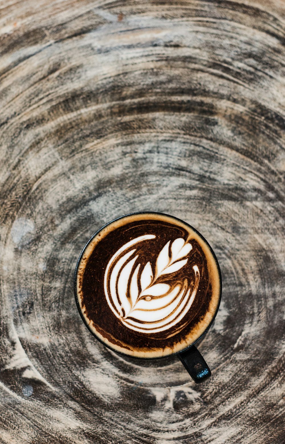 black ceramic mug with cappuccino