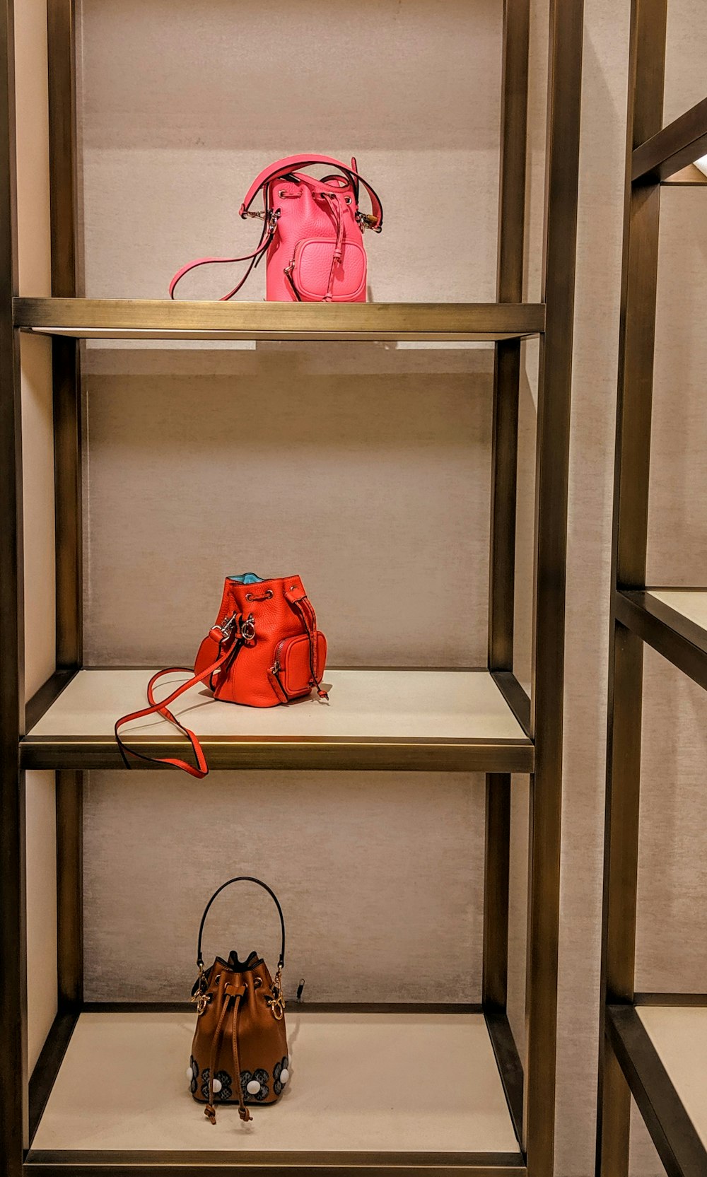 pink, red, and brown leather bucket bags on display