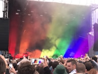 A wide shot of the stage glowing with colorful lights, the crowd swaying in unison.