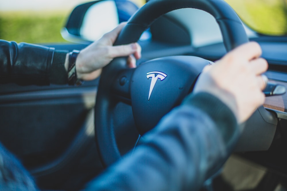 person holding vehicle steering wheel