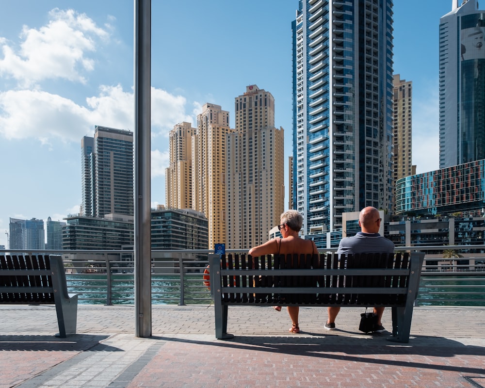 two people sitting on wooden bench during daytime