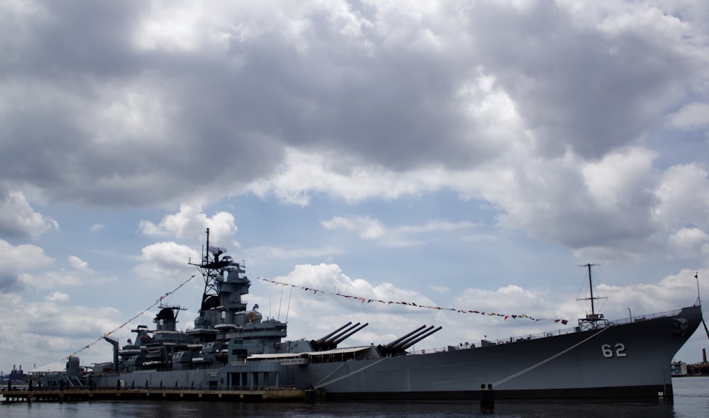 grey and black boat under grey clouds