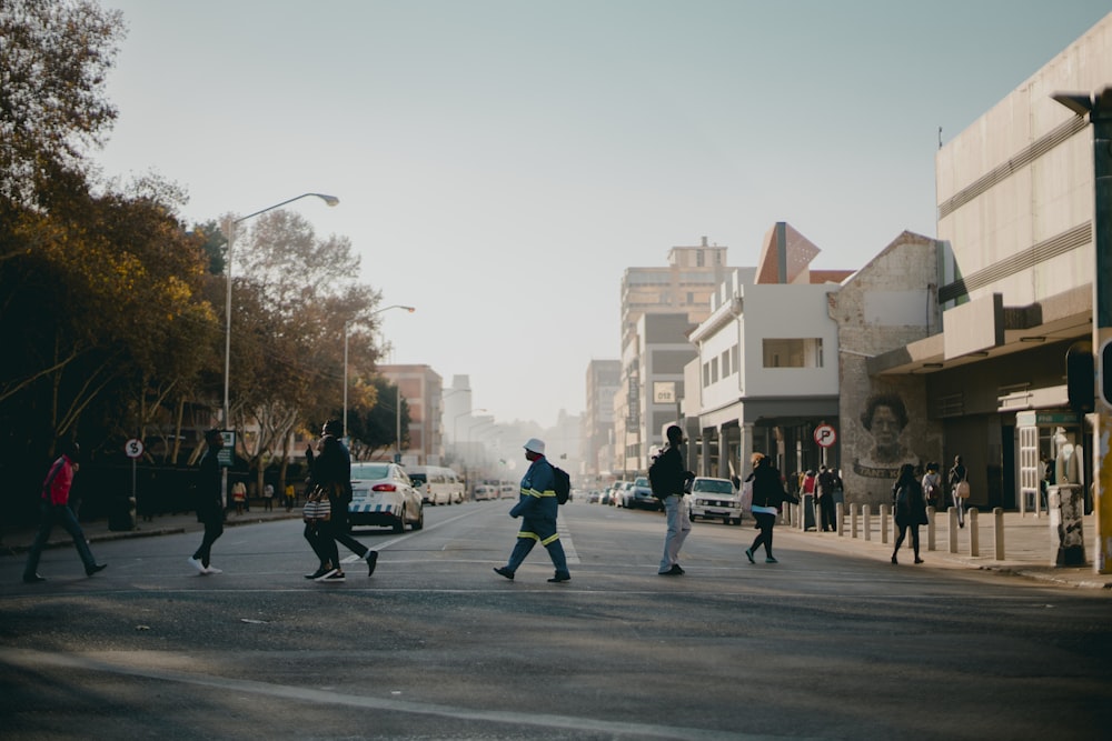 people crossing on pedestrian lane near buildings