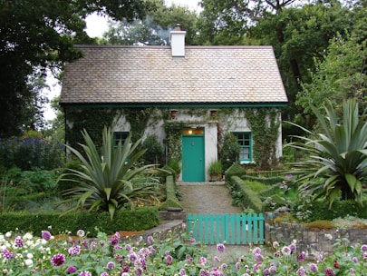 brown and white 1-storey house surrounded by trees