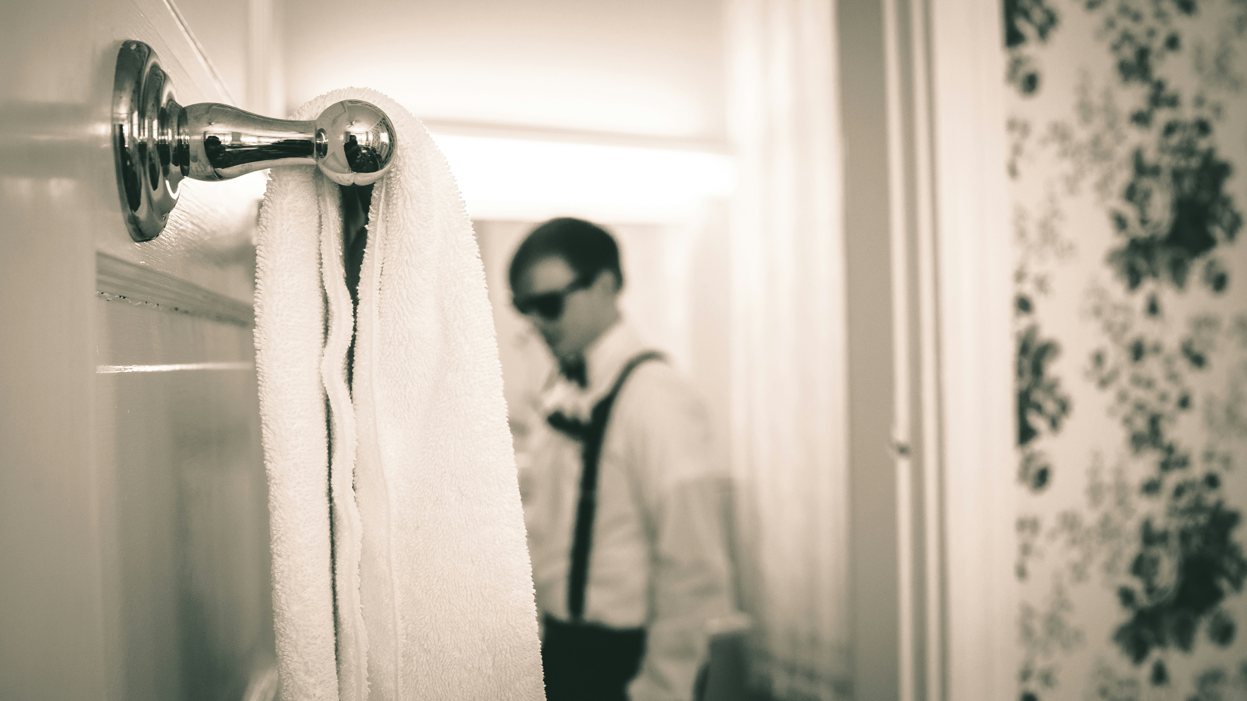 grayscale photography of towel near man wearing long-sleeved shirt