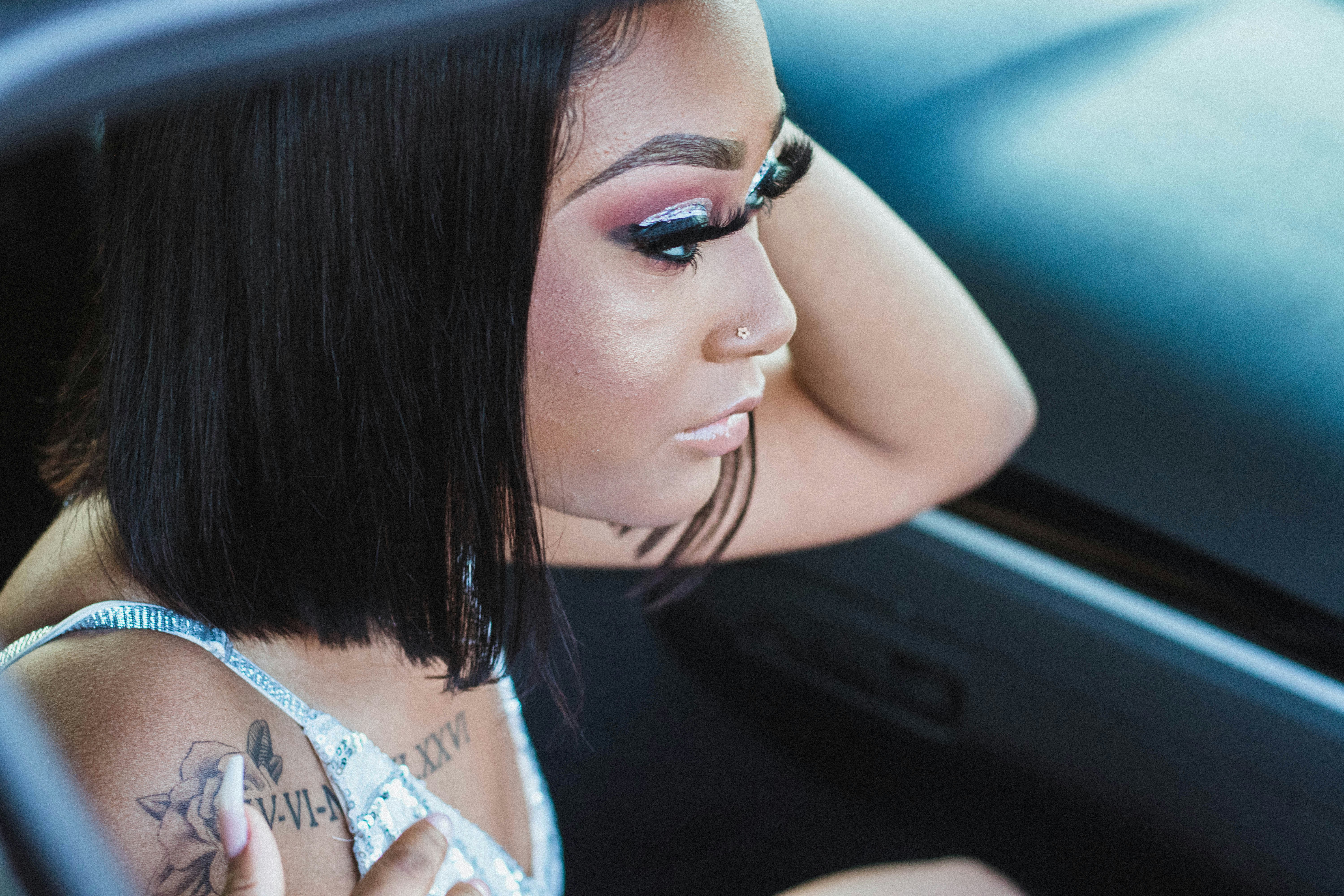 shallow focus photo of woman in white spaghetti strap top prom teams background