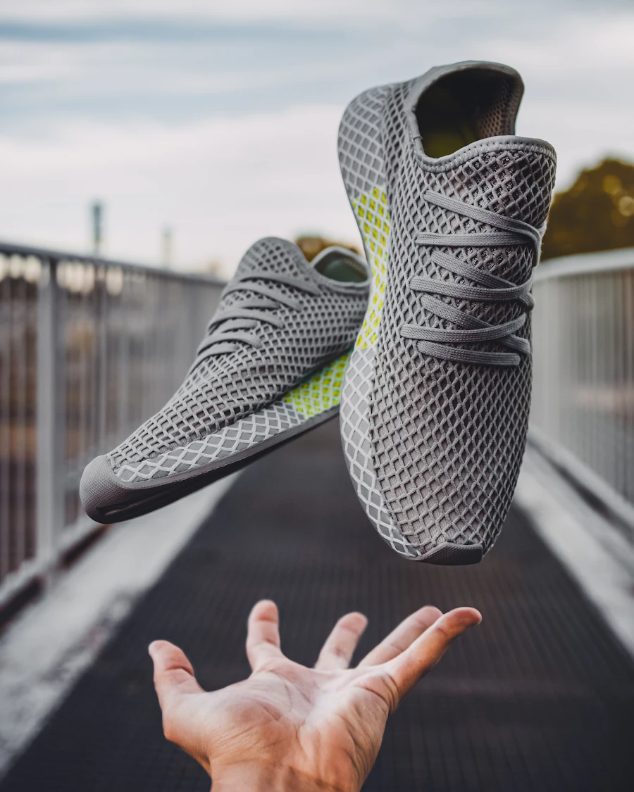A knitted-upper trainer held in one hand
