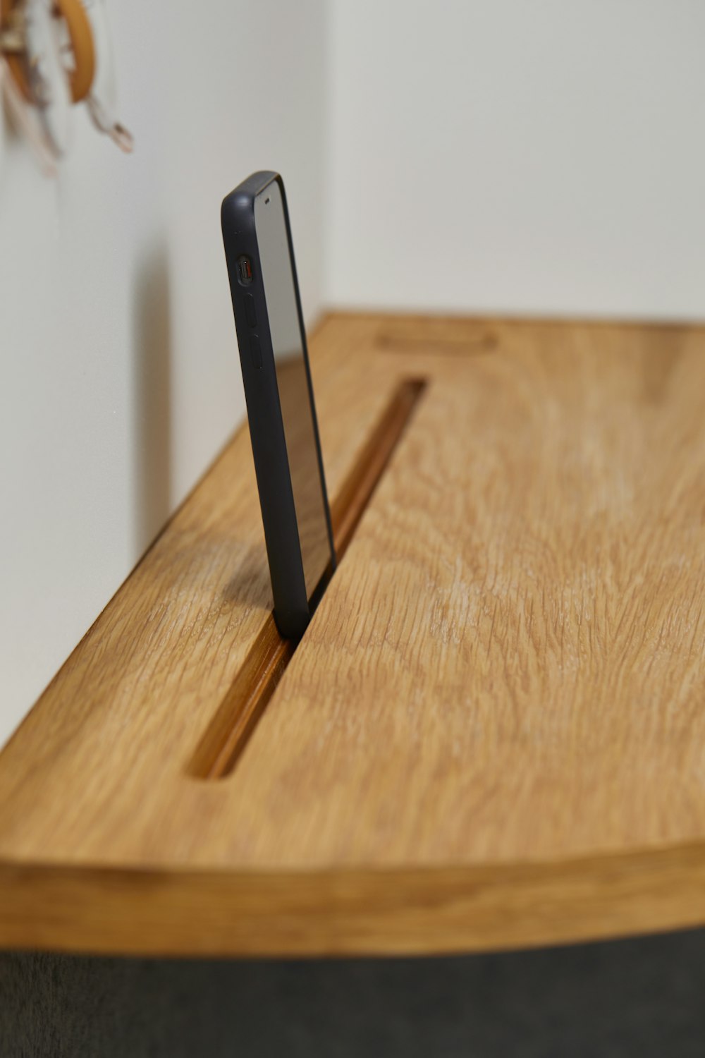 black smartphone on brown shelf