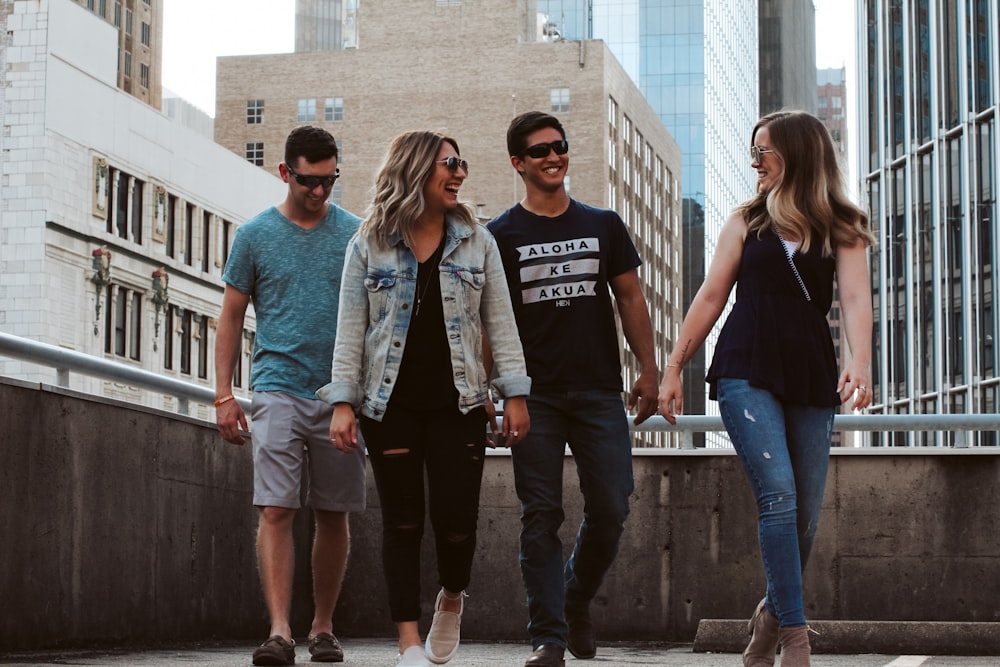 four men and women walking at the roof of a building