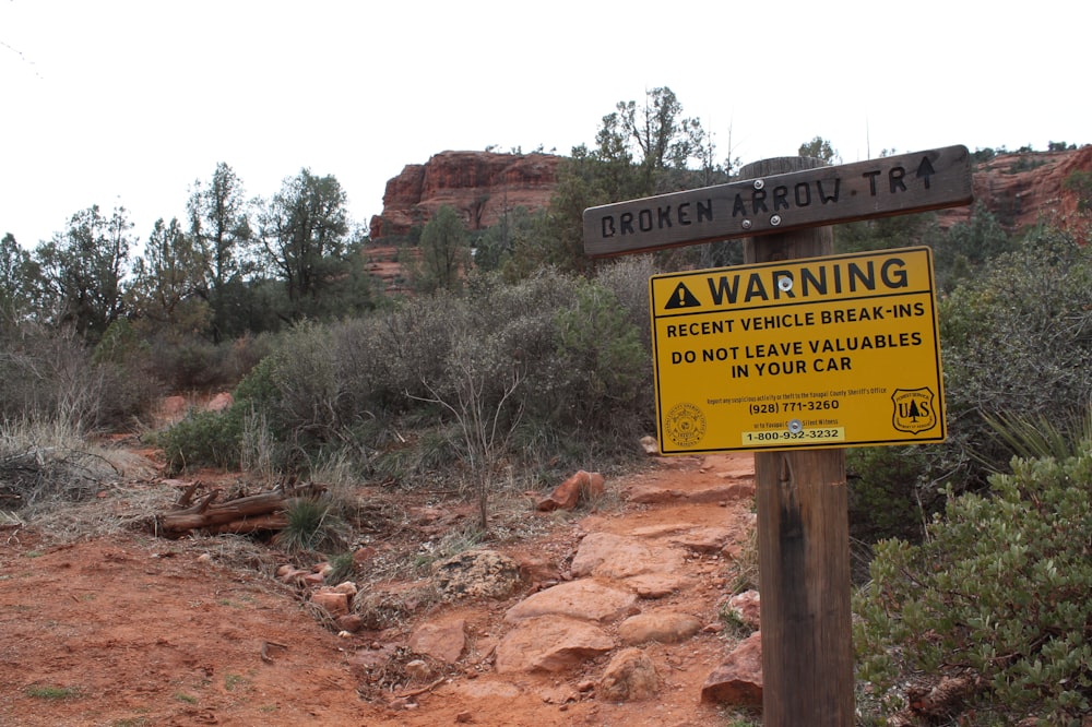 warning signage near trees during daytime