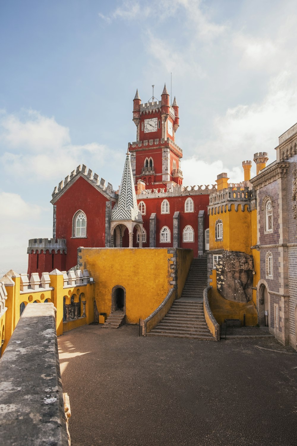 Bâtiment en béton jaune et rouge sous un ciel bleu clair