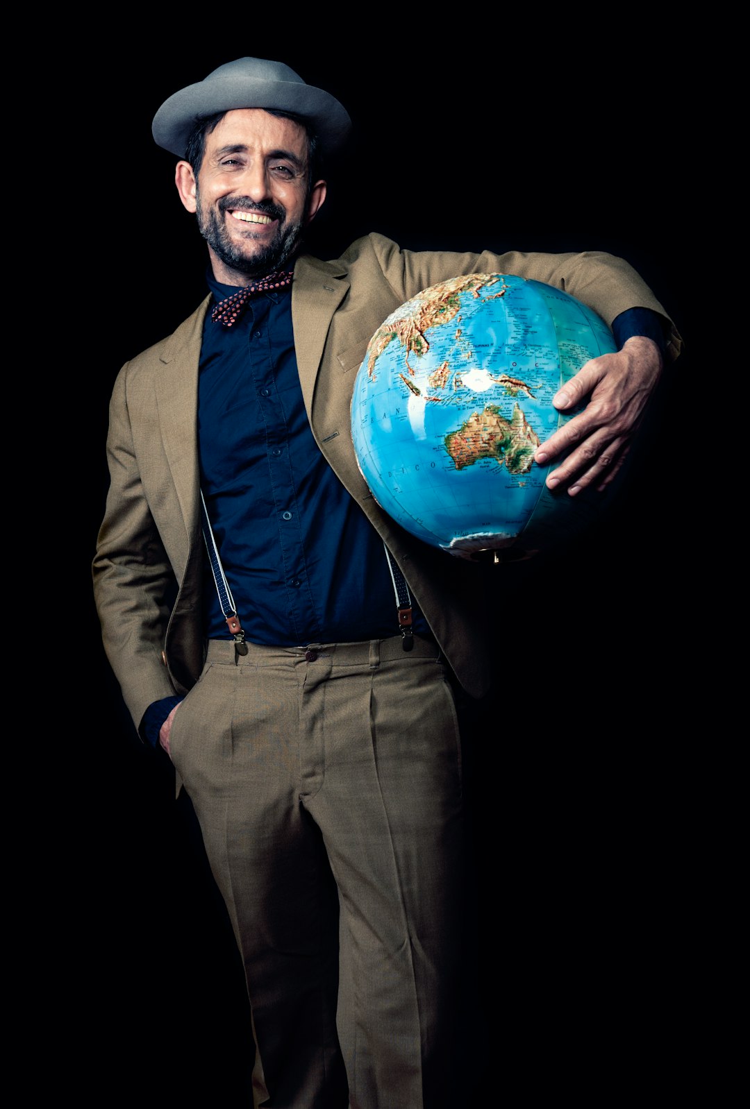 smiling man carrying blue globe