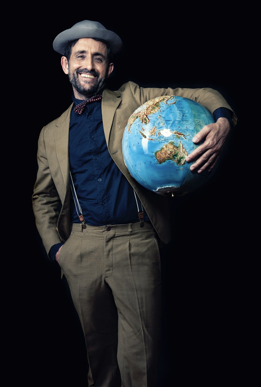 smiling man carrying blue globe