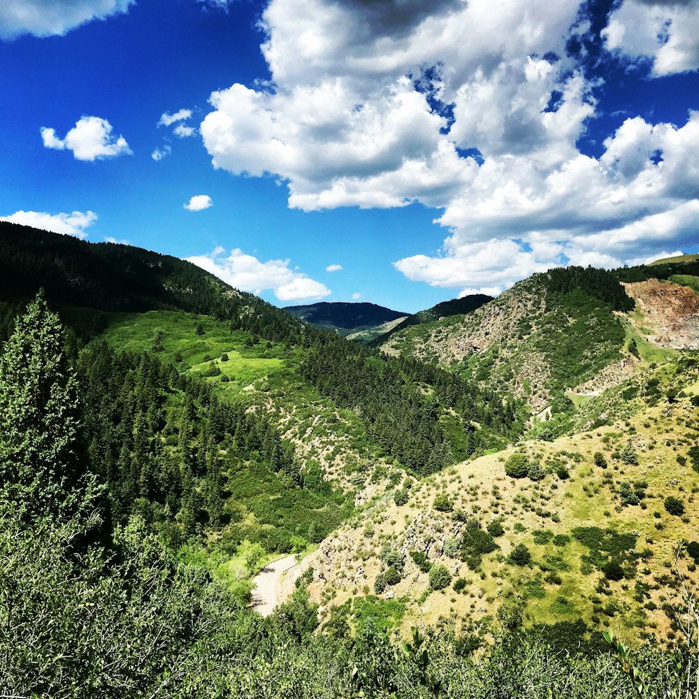 montagna verde sotto cielo blu e nuvole blu durante il giorno