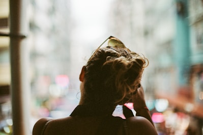 Close-up of a sleek, modern hairstyle with soft city lights in the background