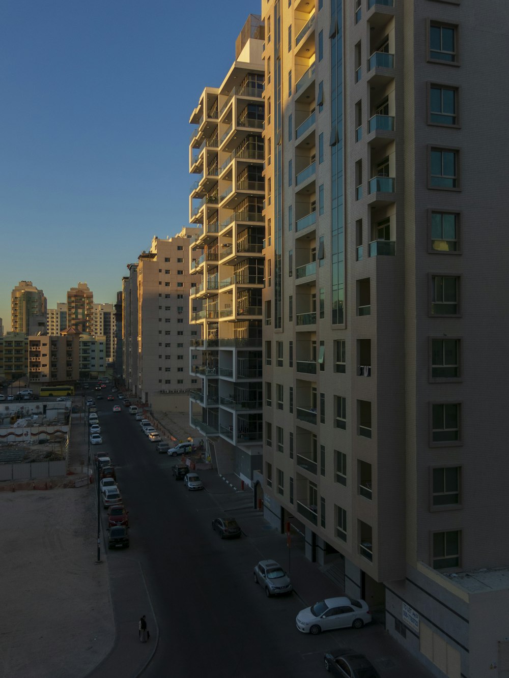 vehicles on road between buildings during daytime