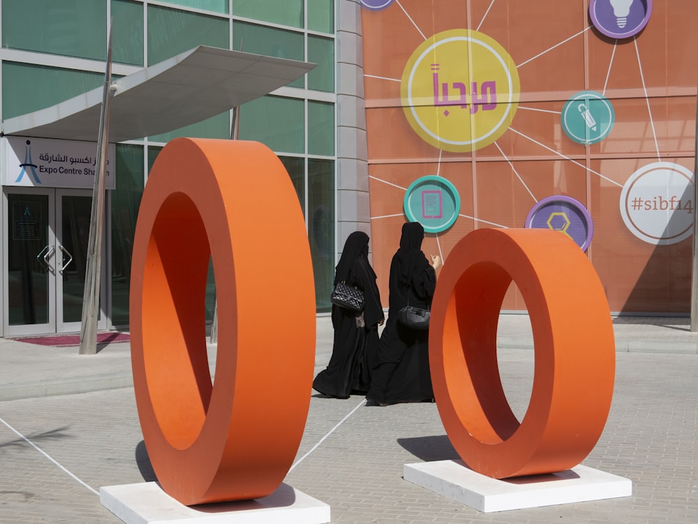 two orange rings statues outside the building