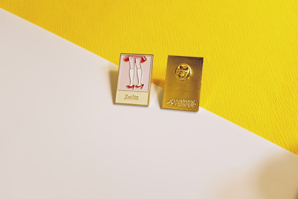 two gold and pink button pins on wall