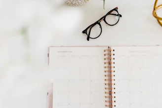 monthly planner book beside eyeglasses