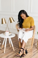 woman in yellow knit shirt sitting on rattan chair