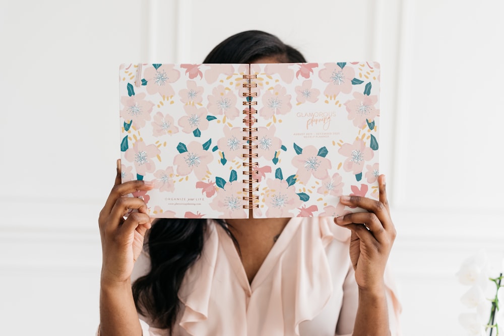 woman holding spiral book