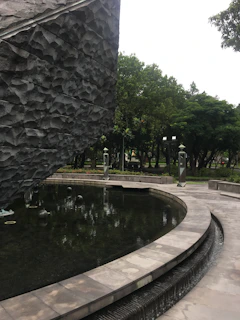 A tranquil water feature surrounded by smooth stones and green foliage inside the spa.