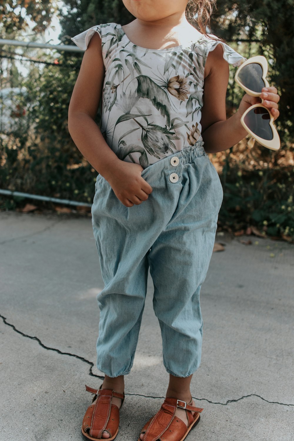 girl standing holding sunglasses
