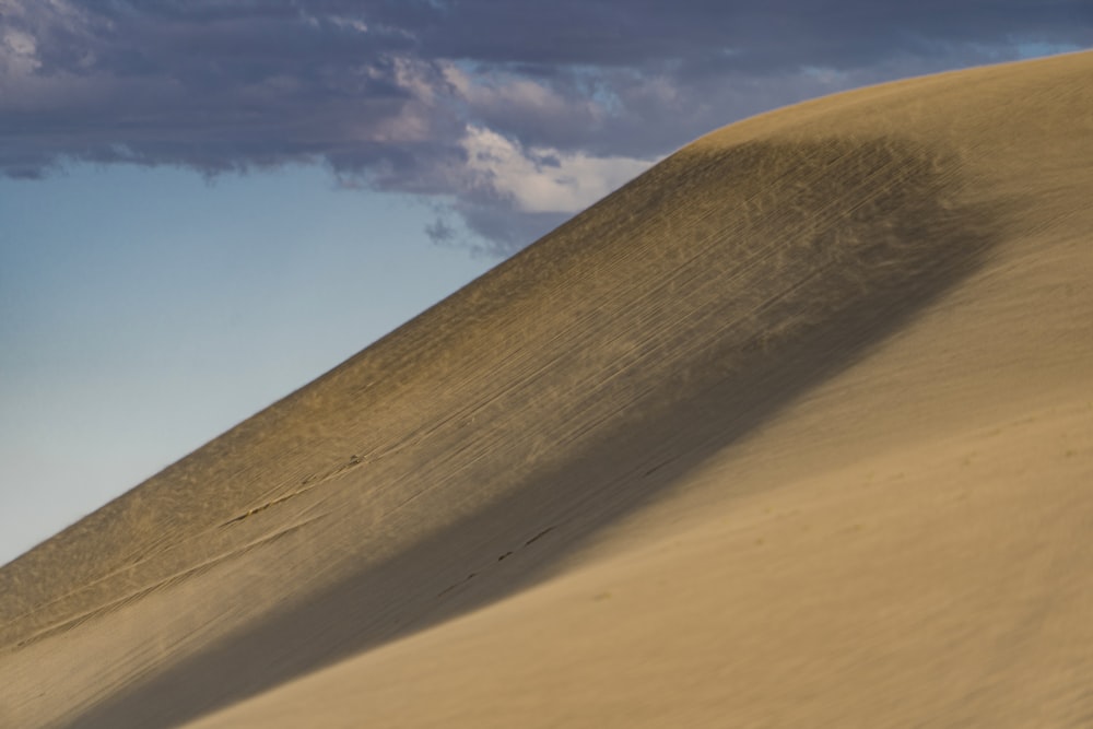 brown deserted mountain under blue and white skies