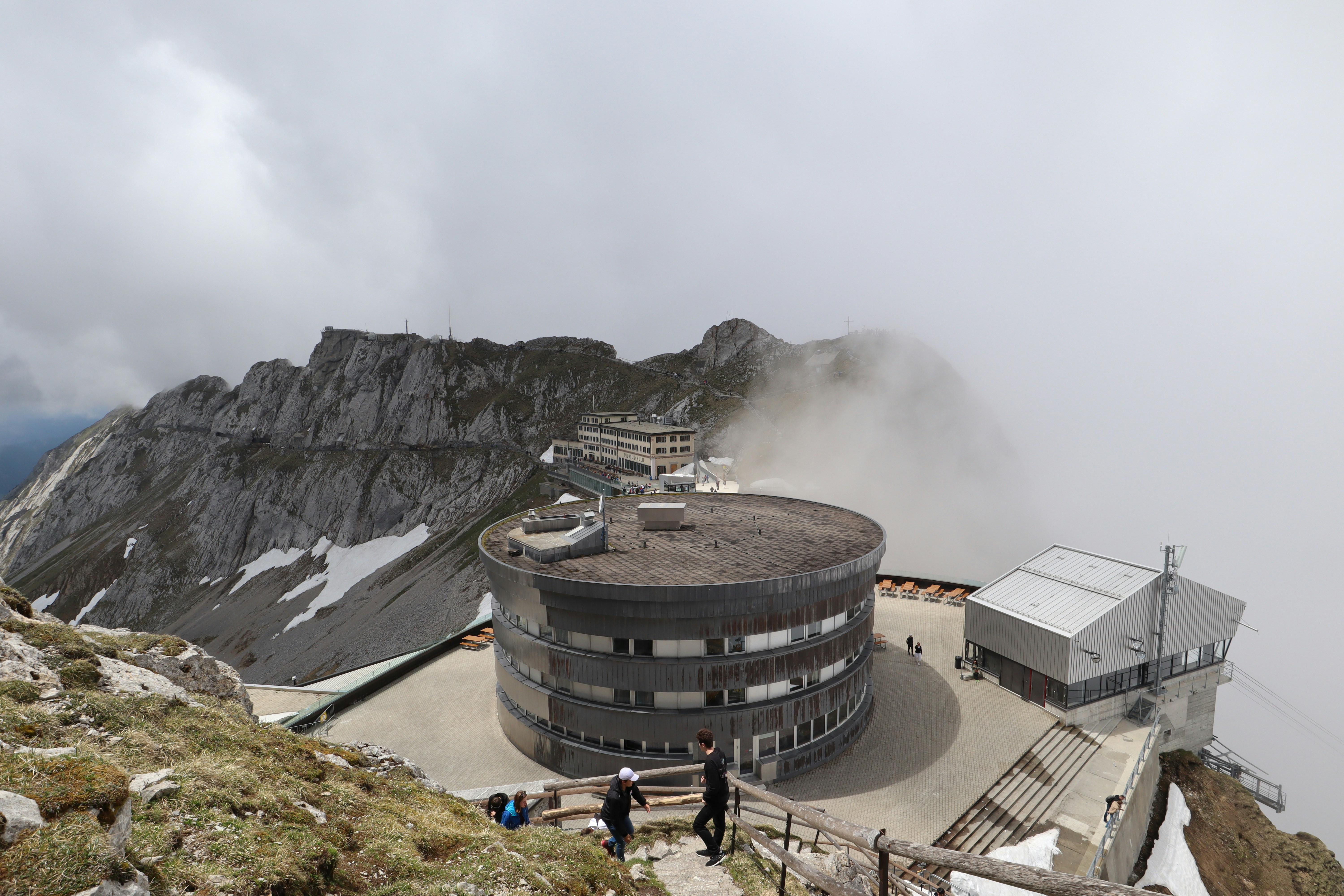 people near rocky hill near buildings