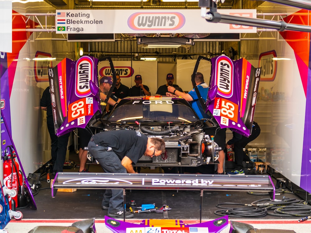 men working in Wynn's race car in pit