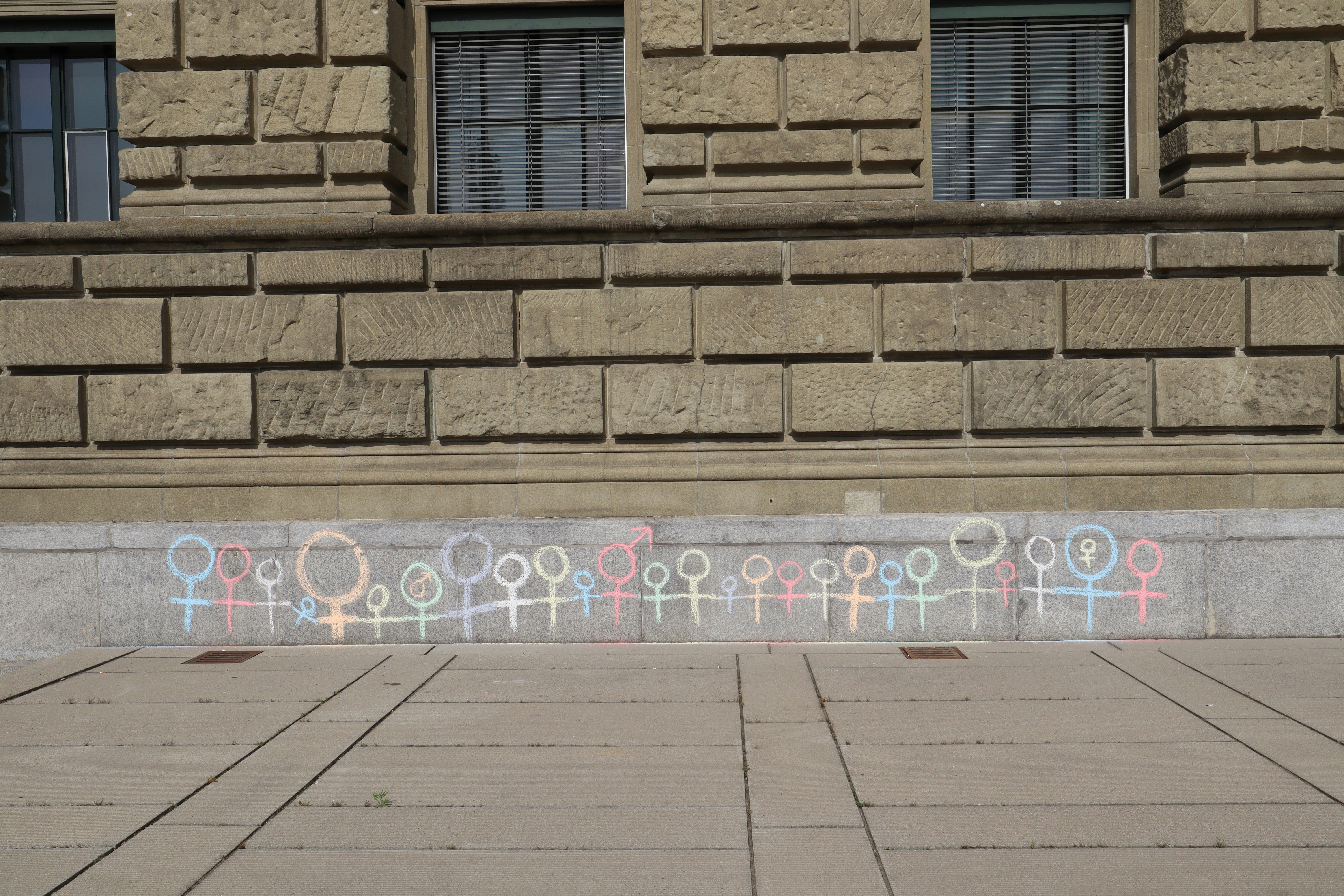 multicolored stick men painted concrete wall
