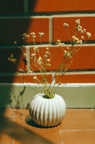 A peaceful corner with a handmade ceramic vase holding fresh wildflowers, bathed in soft afternoon light.