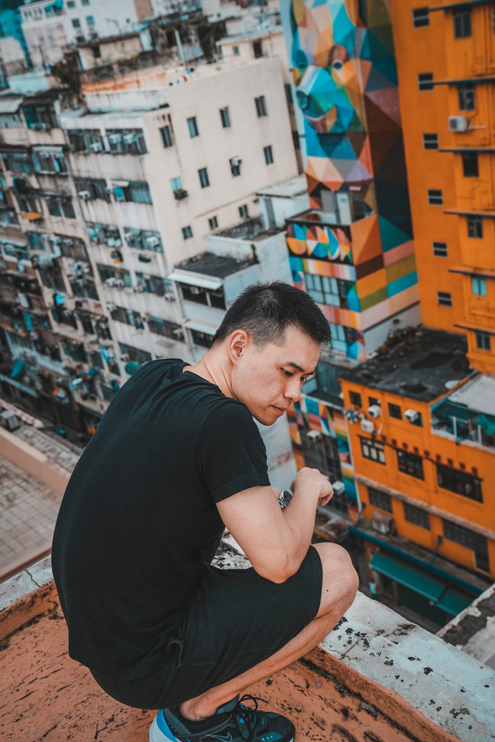 man squatting at the rooftop