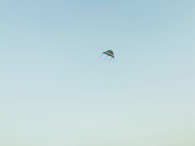 Colorful kite flying high against a clear blue sky during Sankranthi Savari.