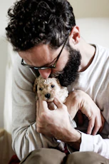 man hugging puppy